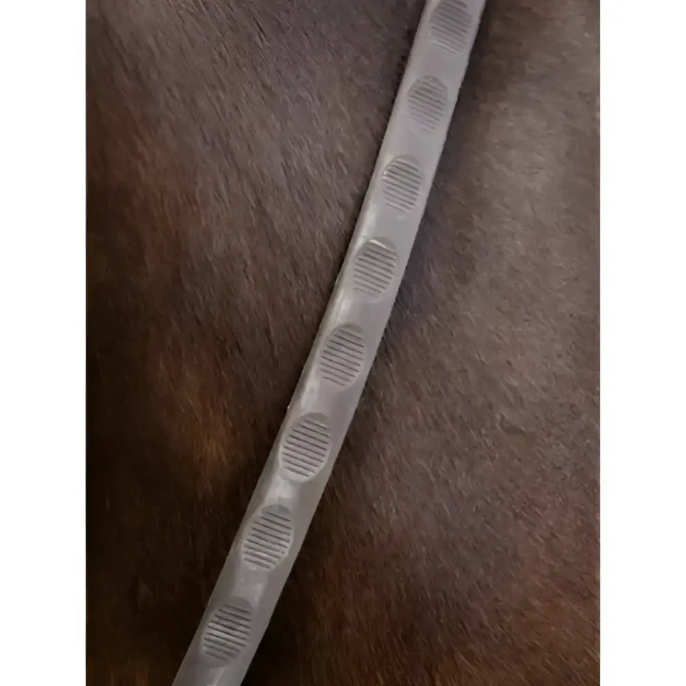 A translucent gray plastic strip with textured ovals used as lemieux magna grip rubber reins brown silver accessory