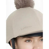 Beige lemieux maria mesh hat cover with fluffy brown pom pom made of silk almond fabric for equestrian helmets