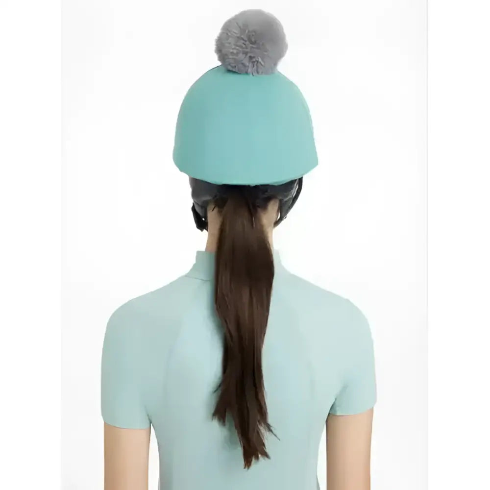 A soft teal knit beanie with a fluffy gray pom-pom from lemieux maria mesh hat silk lagoon collection