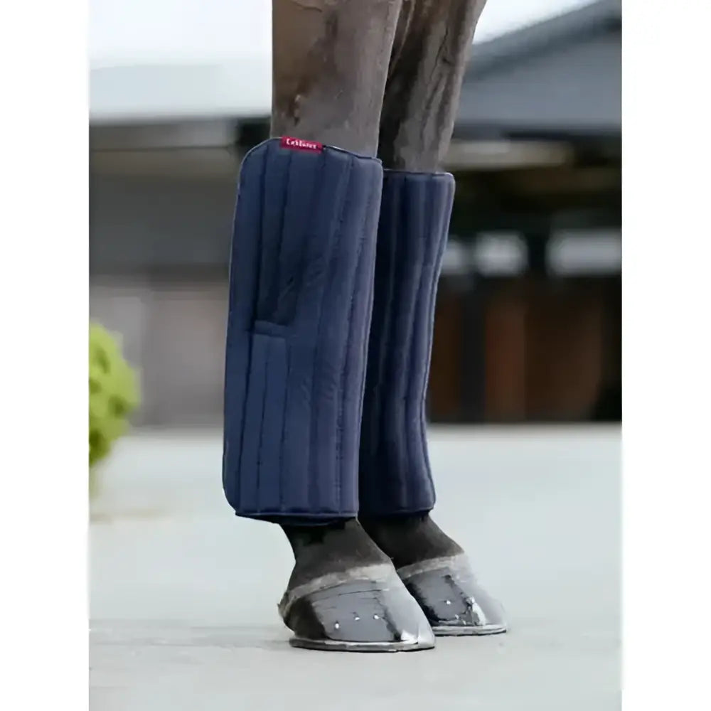Navy blue lemieux memory foam bandage pads with vertical stitching and red tag protect horse’s legs comfortably