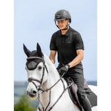 Black equestrian helmet with sleek aerodynamic design and adjustable straps shown with lemieux classique polo shirt black
