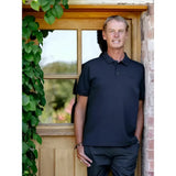 A man wearing a lemieux mens classique navy polo shirt with short sleeves and a subtle logo on the left chest