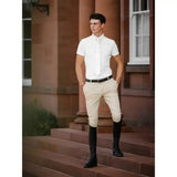 A man wearing lemieux mens pleated beige riding breeches with a tapered fit that reduces bulk and a white shirt and tie
