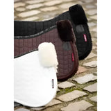 Brown quilted lemieux merino+ half pad with black fur trim and white natural australian merino high quality half pads next to it