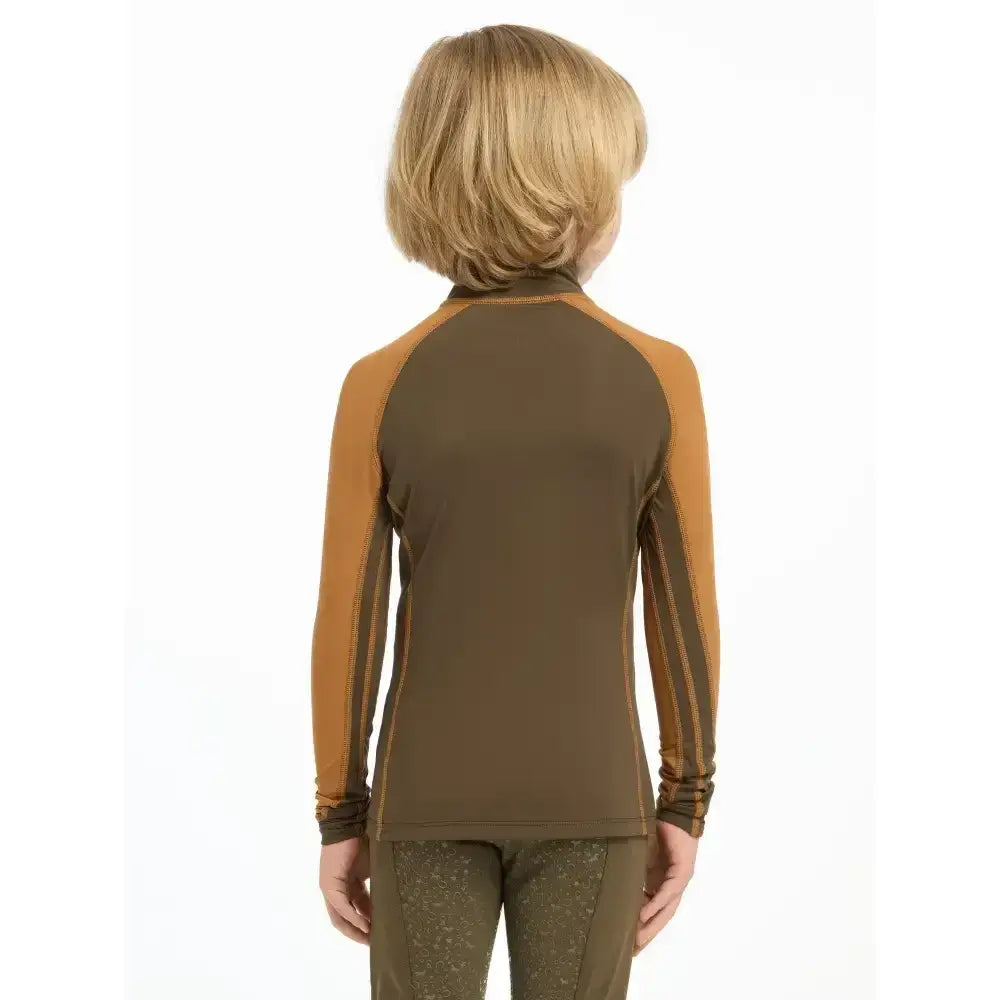 A child wearing a lemieux mini base layer alpine long sleeve with olive green body and mustard yellow striped sleeves