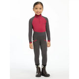 A child wearing a lemieux mini base layer ember suit with a magenta torso and gray sleeves perfect for mini riders running