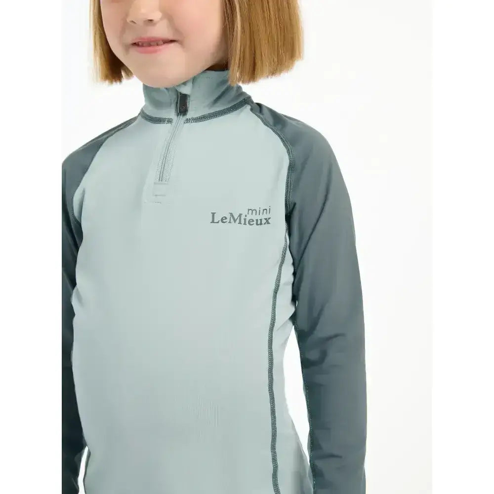 Light blue and dark gray lemieux mini base layer glacier long-sleeve quarter-zip top for mini rider’s running