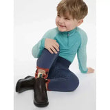 Child wearing lemieux mini base layer lagoon in teal long sleeve top and navy leggings with sparkly details