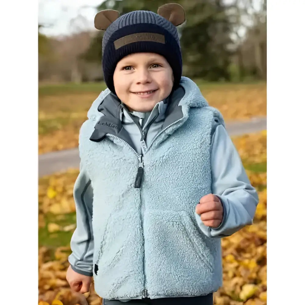 Light blue fleece vest with hood and front zipper worn over matching jacket in lemieux mini bear beanie petrol style