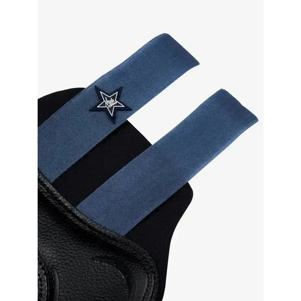 Blue elastic strap with black star patch and vogue logo on black textured leather of lemieux mini brushing boots indigo