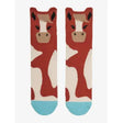 A pair of lemieux mini character red and white cow-themed socks with black ears tan face and light blue toe caps