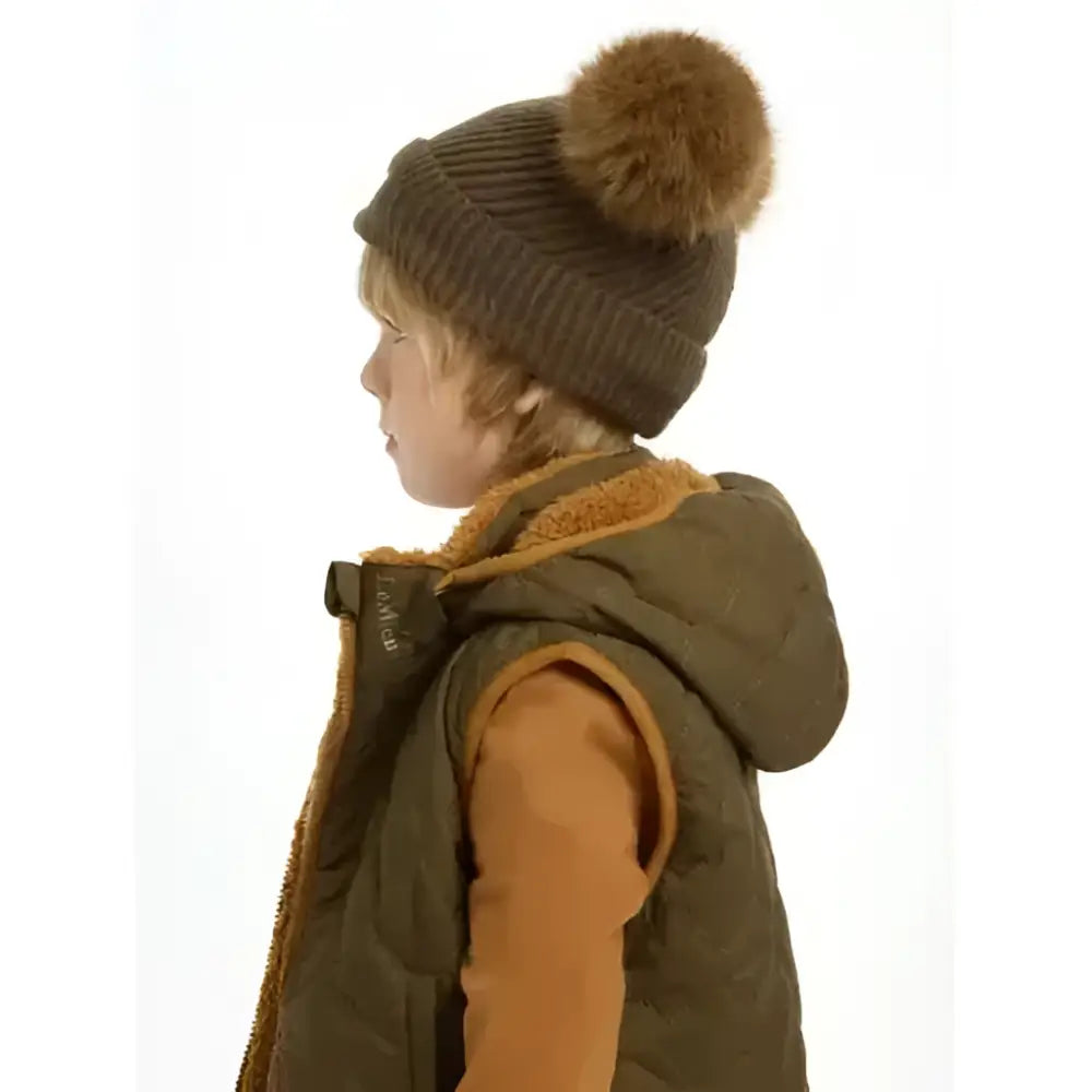 A cozy brown knitted lemieux mini clara beanie with a fluffy tan pom-pom perfect for alpine use