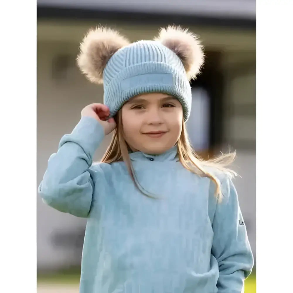 Light blue knitted lemieux mini clara beanie glacier with fluffy brown pom-poms on top for cozy winter wear