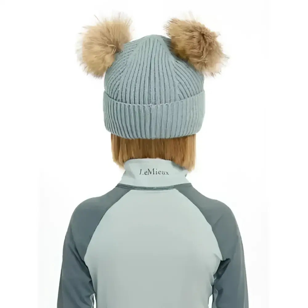Light blue ribbed knit lemieux mini clara beanie with two tan fluffy pom-poms called clara beanie glacier