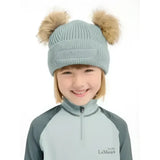 Light blue knitted lemieux mini clara beanie glacier with two fluffy tan pom-poms on top perfect for chilly days