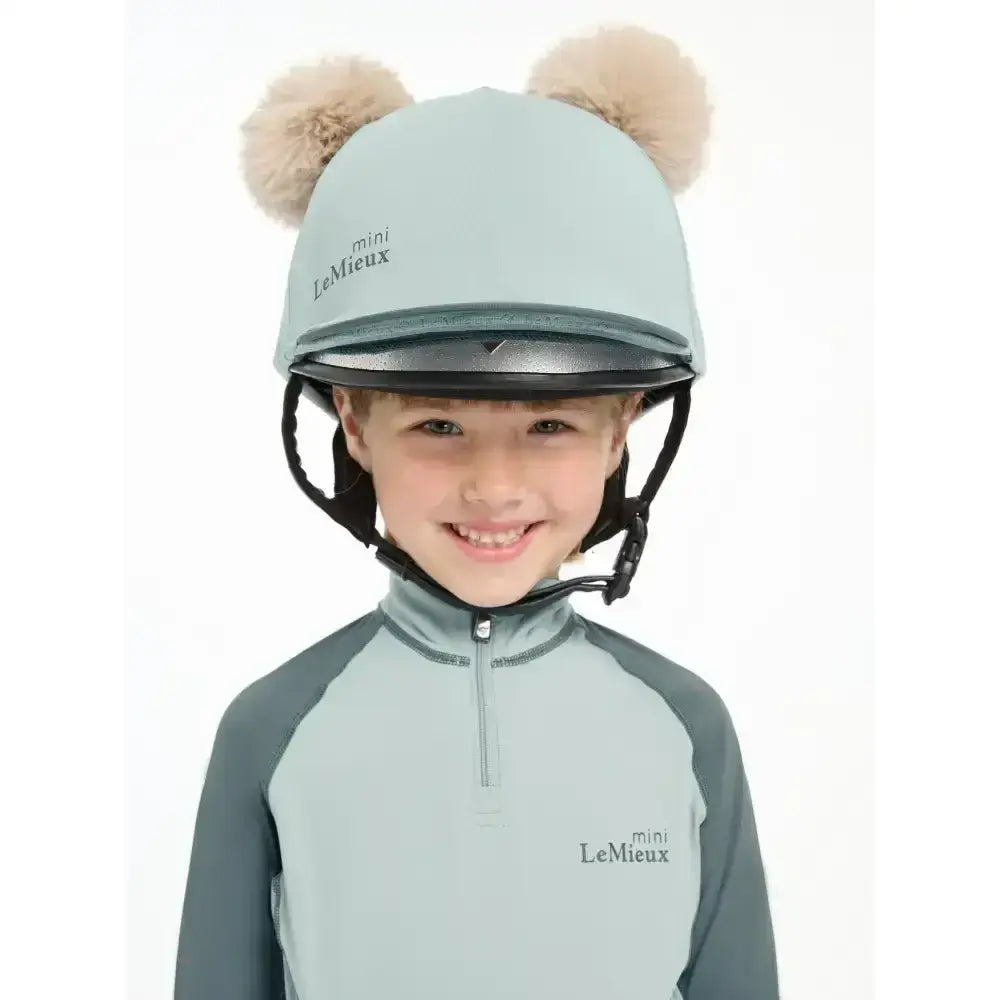 Light blue lemieux mini double pom hat silk glacier equestrian helmet with fluffy beige pom-poms on top