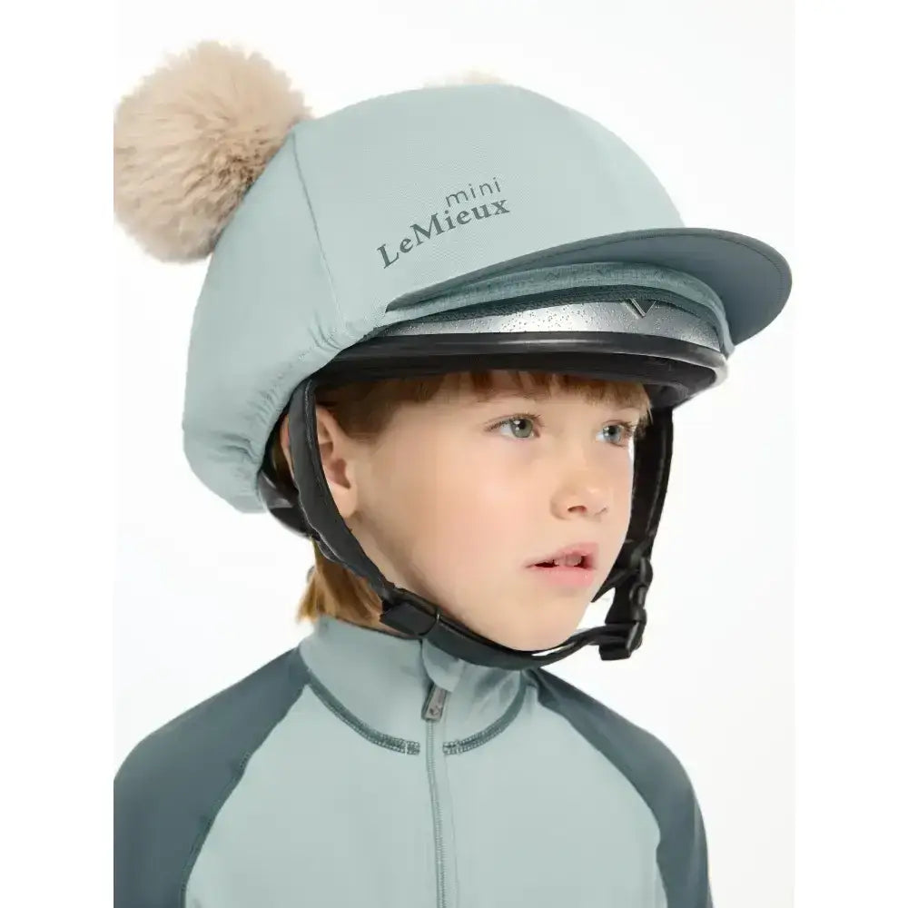 Light blue lemieux mini double pom hat silk glacier padded equestrian helmet with fluffy beige pom-pom on top
