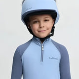 Light blue lemieux mini double equestrian helmet with silk powder blue faux fur trim and mini double pom