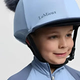 Light blue lemieux mini double pom equestrian helmet cover with fluffy gray pom-pom in silk powder blue