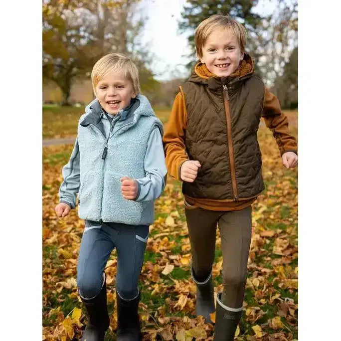 Two boys wearing lemieux mini elsie reversible gilet alpine in light blue fleece and brown quilted vest for autumn outdoor fun