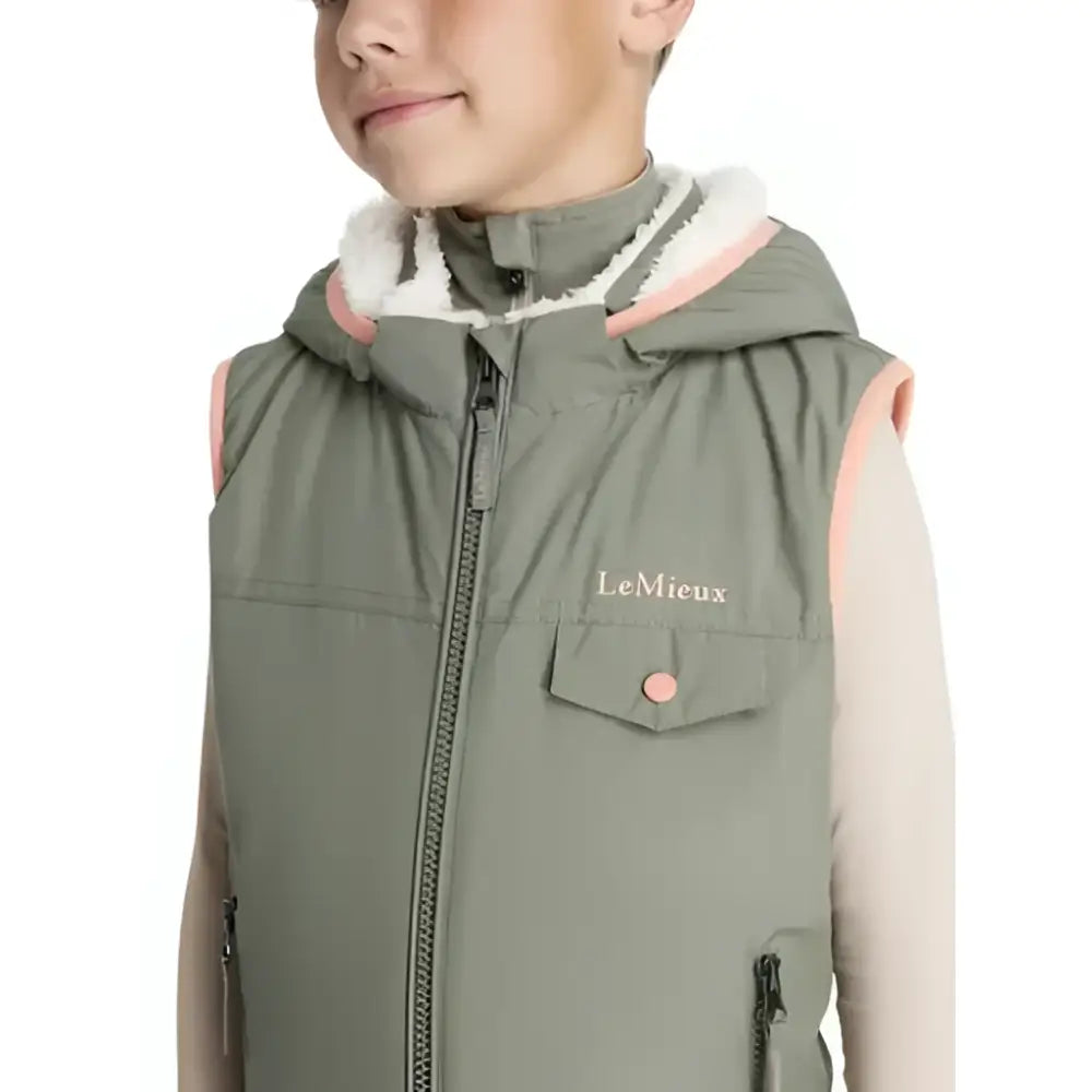 Olive green lemieux mini george quilted gilet with pink trim white shearling hood and chest pocket embroidery