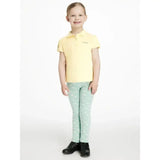 A child wearing lemieux mini leggings in light green with white hearts and a pale yellow polo shirt with brand logo