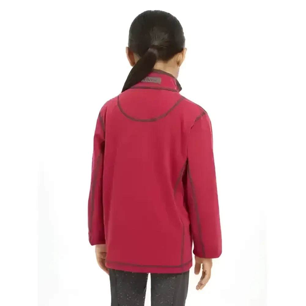 A child wearing a lemieux mini mari micro fleece ember jacket in vibrant red with dark gray trim