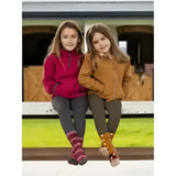 Two kids sit on a bench wearing lemieux mini mari micro fleece ember jackets in red and brown fleece material