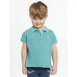 A child wearing a teal lemieux mini polo shirt lagoon with white trim and star buttons on collar and sleeve cuffs