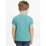 A child wearing a lemieux mini polo shirt lagoon in teal with white trim and star buttons on collar and cuffs