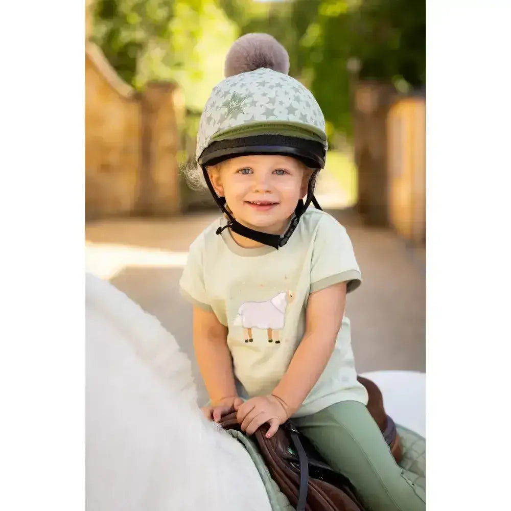 Light green lemieux mini pom equestrian helmet with gray star pattern and fluffy gray pom pom in hat silk fern design