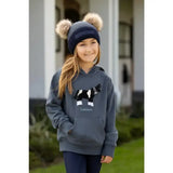 Gray lemieux mini romi hoodie petrol with black and white cow graphic paired with navy beanie with beige pom poms