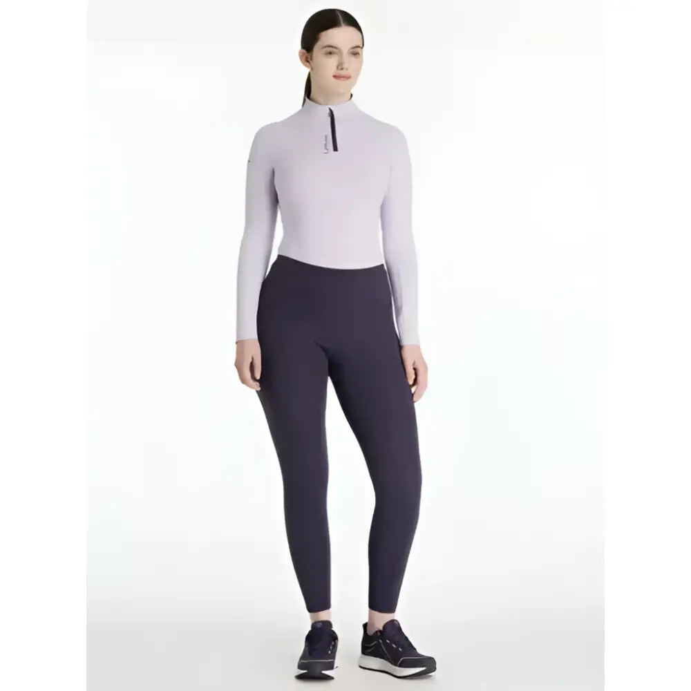 A woman wearing lemieux natalie brushed pull with a lavender high-neck zip top and dark navy leggings