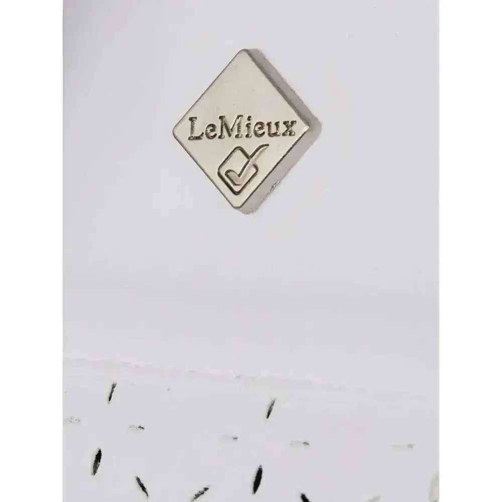 Silver diamond-shaped pin with lemieux and checkmark engraved on lemieux olivia short featuring intricate diamante detailing