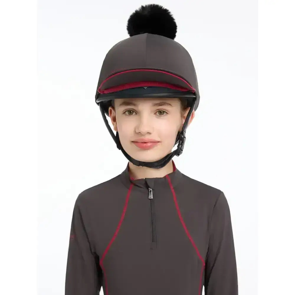 Dark gray lemieux pippa hat with black pom-pom and red trim made of silky smooth four-way stretch hat silk cinder