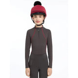 A maroon lemieux pippa hat with black faux-fur pom-pom in silk ember perfect for equestrian use