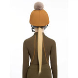 A mustard-yellow lemieux pippa hat silk ginger with a fluffy gray pom-pom perfect for equestrian use