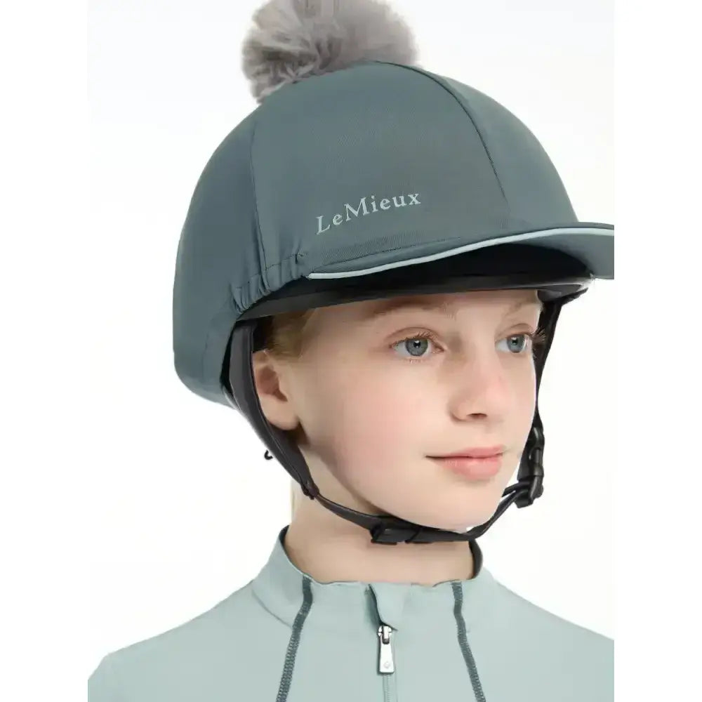 Gray lemieux pippa hat silk petrol with fluffy pom-pom made from silky smooth four-way fabric for equestrian use