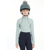 A sleek light green lemieux pippa hat silk long-sleeved equestrian top with black zipper and silky smooth four-way stretch