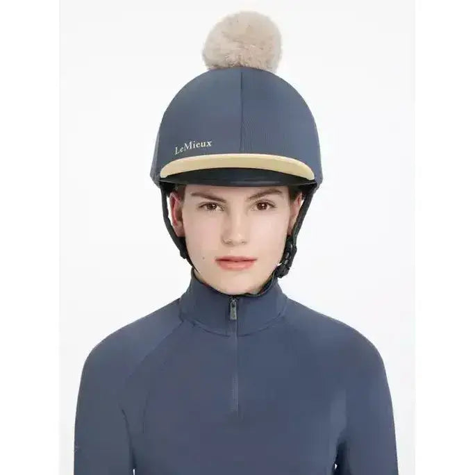 Navy blue lemieux pom hat silk dusk mimosa with beige trim and fluffy pom pom on top perfect for equestrian use