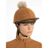 Tan lemieux pom hat equestrian helmet with a fluffy beige pom pom dark brown trim silky smooth four way hat silk ginger