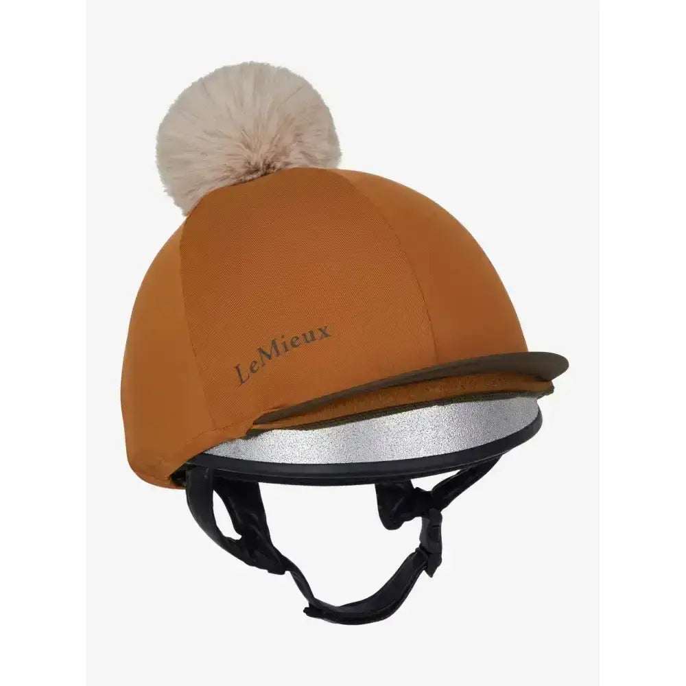 A warm orange lemieux pom hat with a fluffy white pom pom and silver reflective band in silky smooth four way hat silk ginger