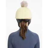 Cream-colored lemieux pom hat silk mimosa stone equestrian helmet with fluffy gray pom-pom on top