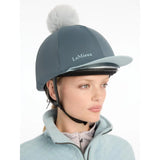 A sleek slate-gray lemieux pom hat with a soft white pom-pom made from silky smooth four-way hat silk petrol fabric