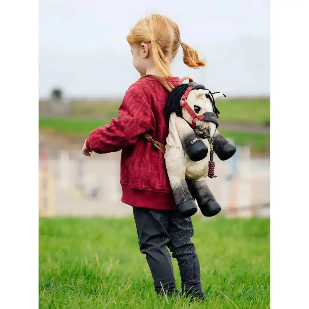 Plush white and black horse-shaped lemieux pony bag with red harness straps called pony bag dream
