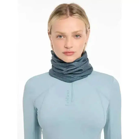 A soft heathered blue lemieux printed stretch snood worn snugly around the neck for cozy warmth