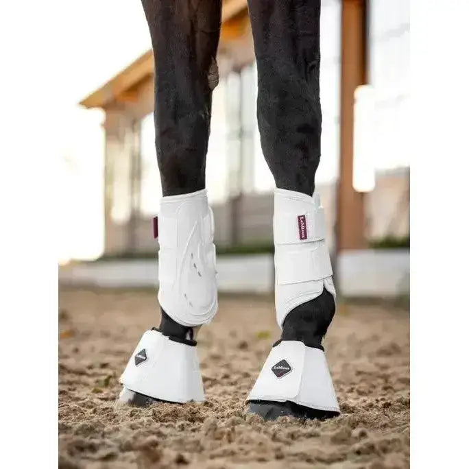 White proshell brushing boots by lemieux with black accents and adjustable straps for equestrian use