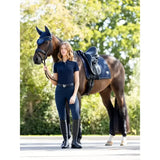 Dark blue lemieux puissance suede dressage pad with matching riding outfit and tall boots in suede dressage style
