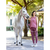 A woman in pink stands beside a gray horse holding a lemieux rope halter blossom lead rope in gray color
