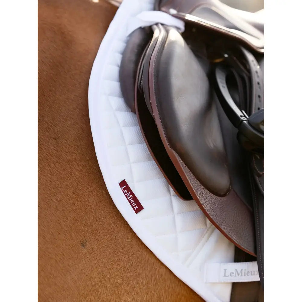 Black leather close contact half saddle with brown edges resting on white lemieux self-cool close contact half square pad